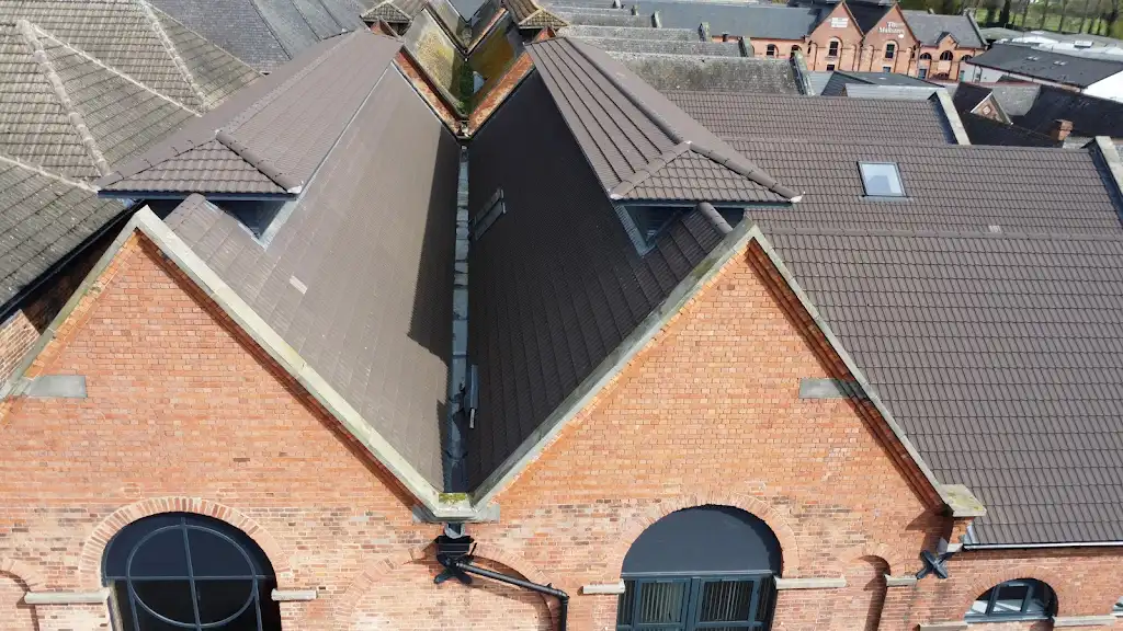 Aerial view of a red brick converted building with new dormer roofs