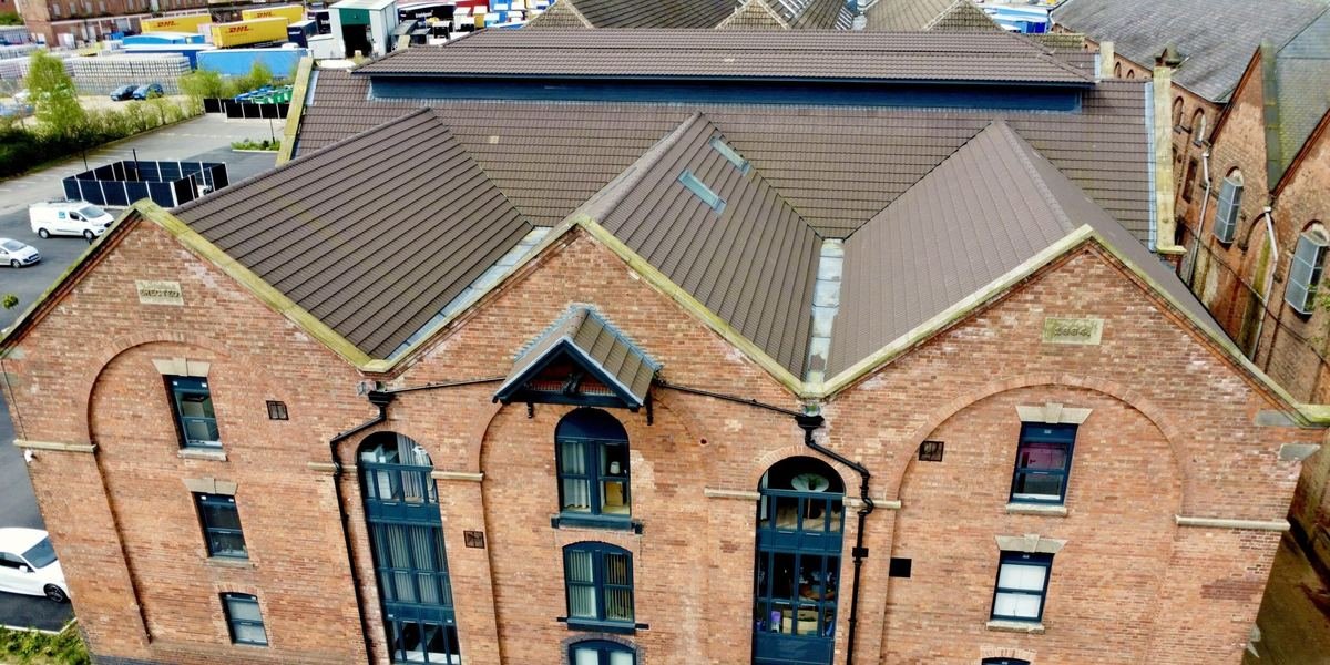 Aerial photo of a commercial brick building with a new tiled roof, built by HK Builders Ltd
