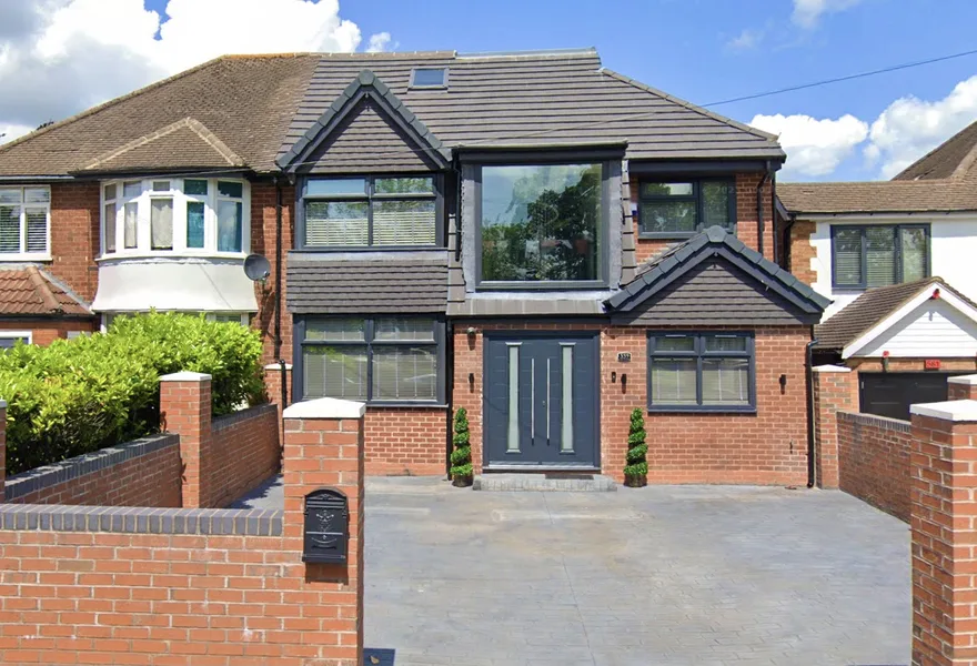 Semi-detached house with a modern two storey front extension and grey cladding