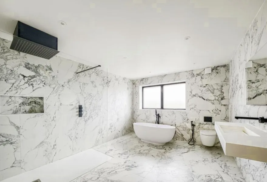 Bathroom with marble style tiles, a freestanding bath and a walk in shower