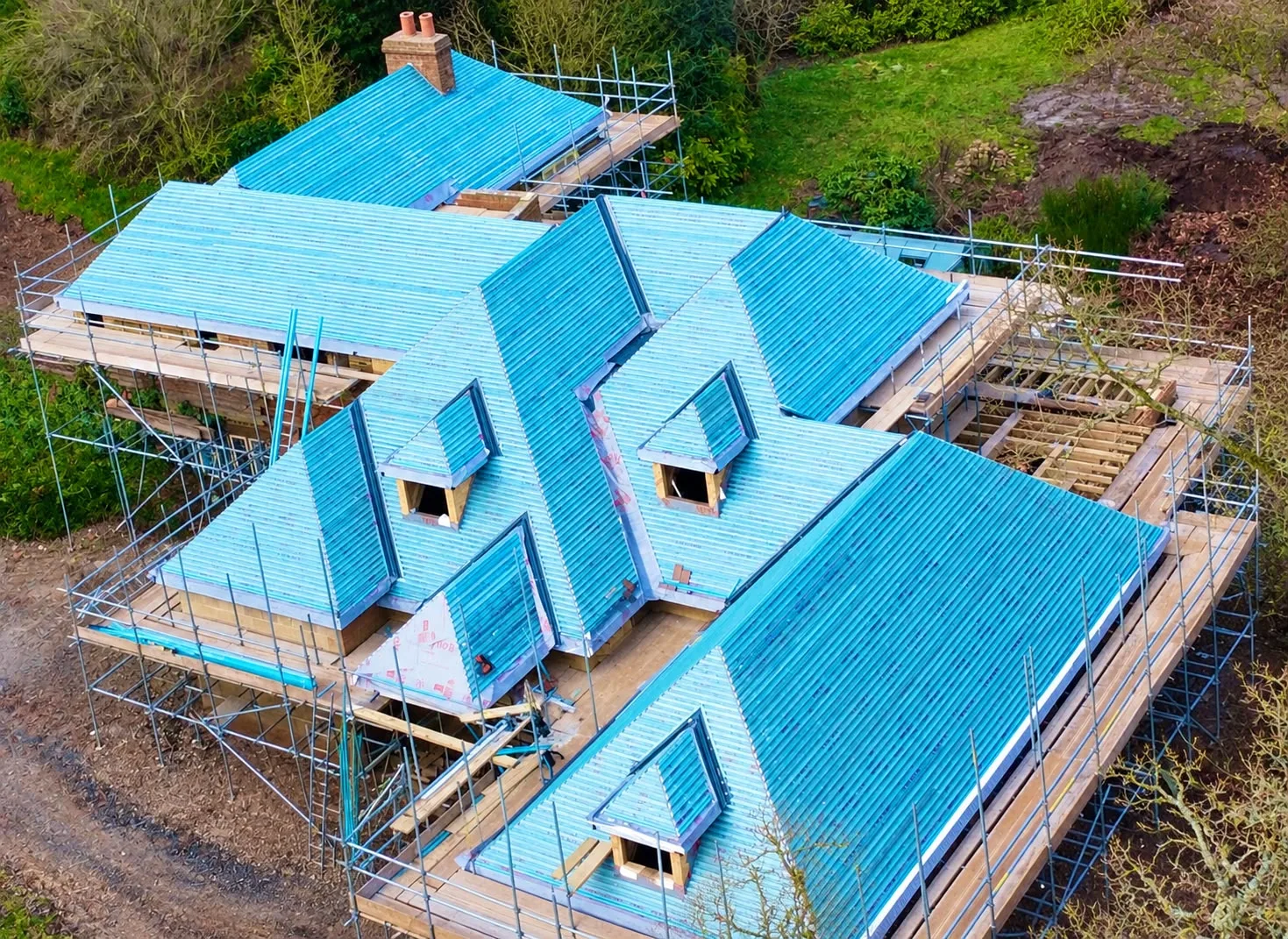 Aerial view of a new roof with blue breathable membrane and scaffolding
